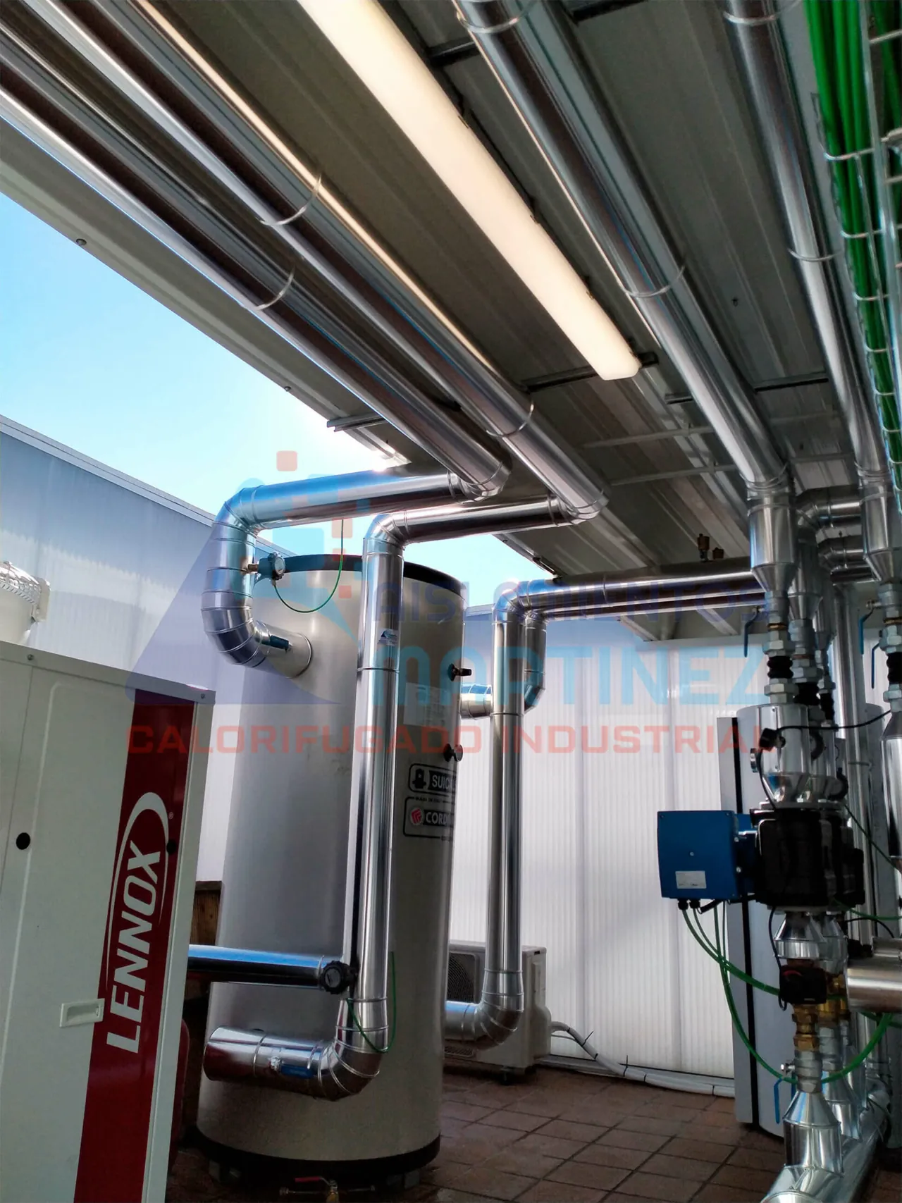 Tuberías revestidas en metal con recorridos elevados y cambios de dirección en una zona técnica.